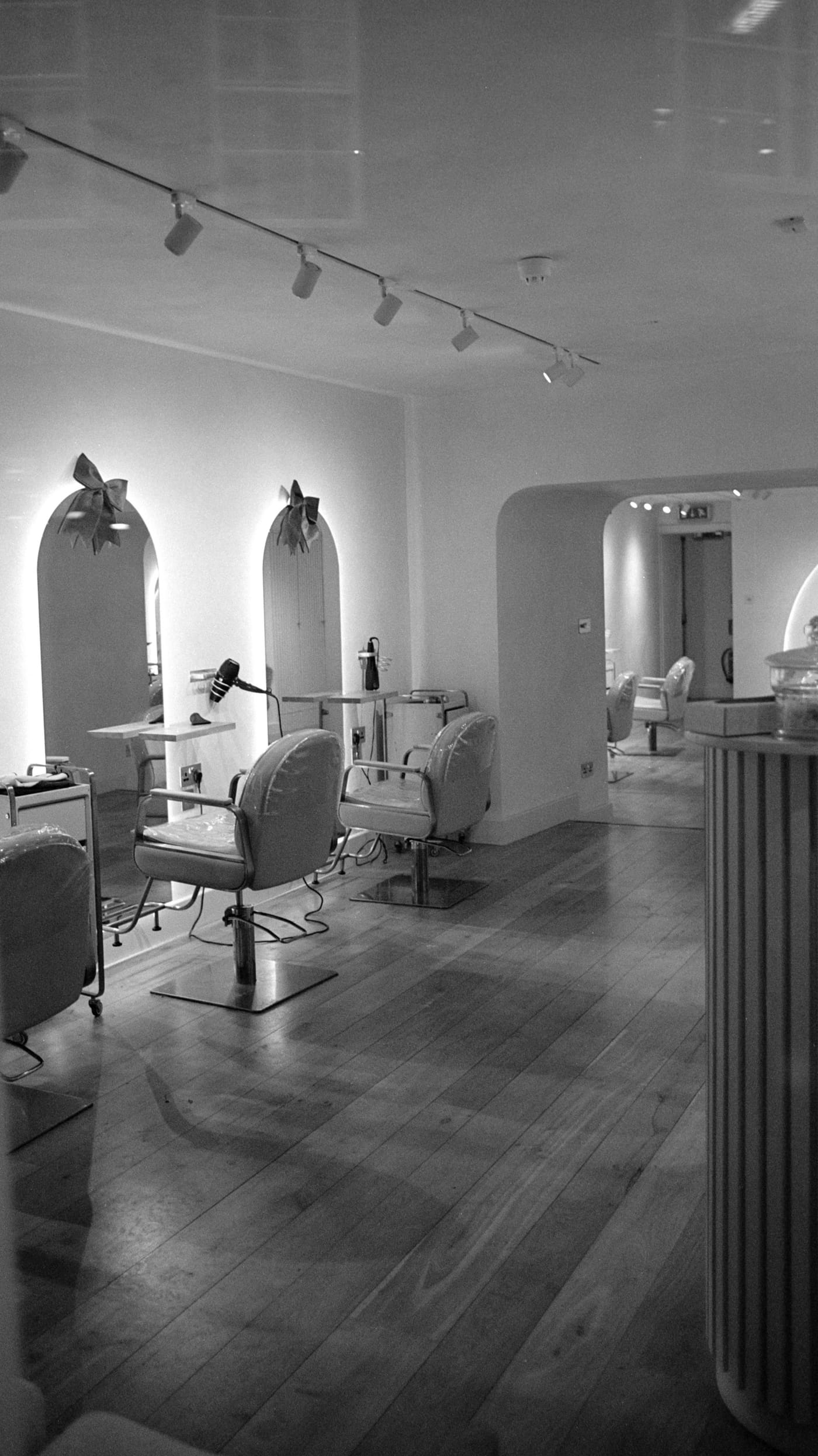 Inside the Lumière atelier: salon chairs beneath arched mirrors under warm light