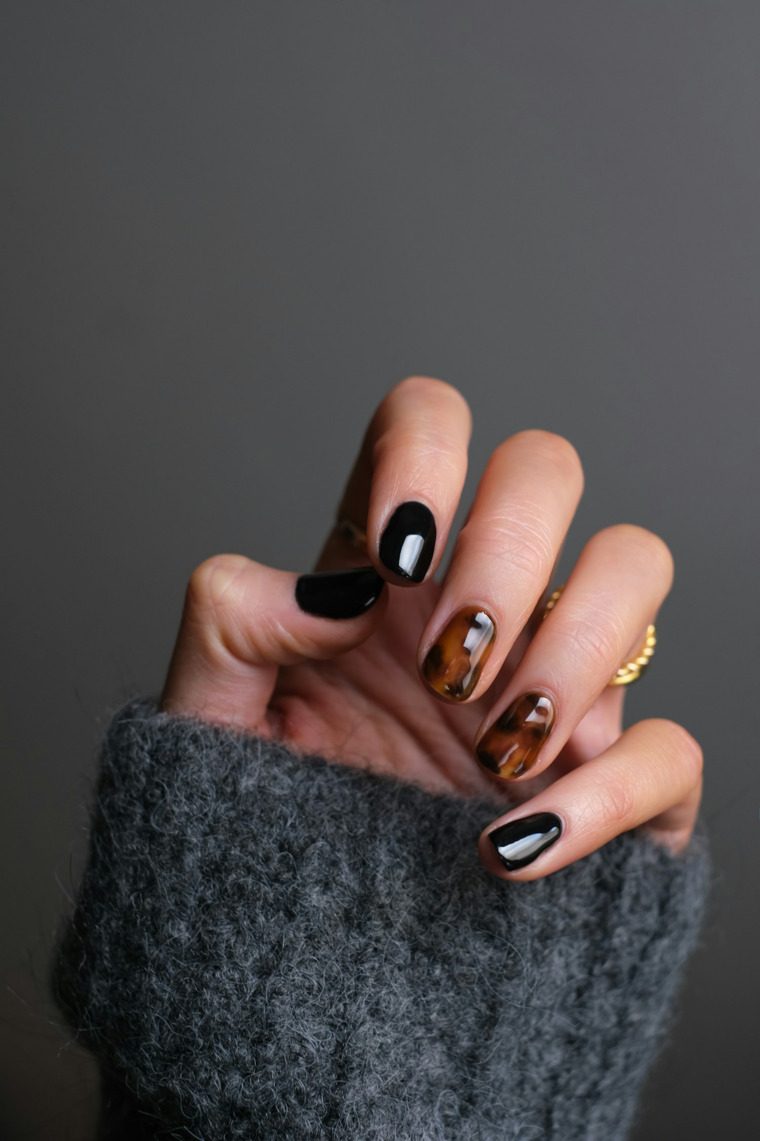 A hand with a glossy tortoiseshell manicure